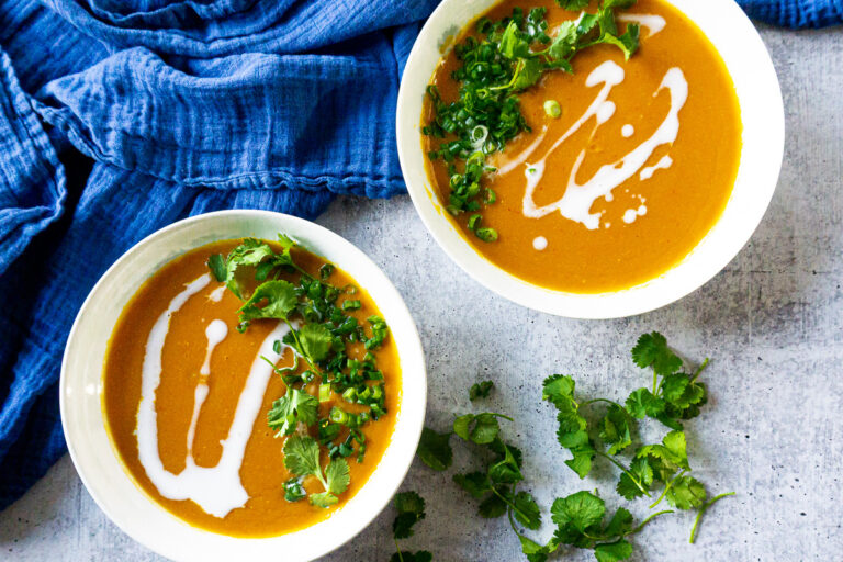 Two bowls of Thai Sweet Potato and Lentil Soup with scallions and cilantro