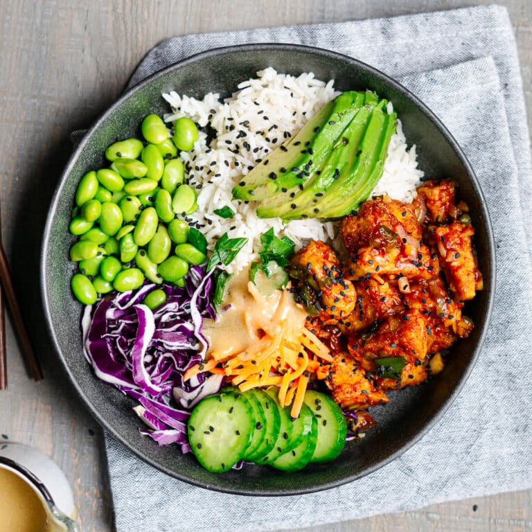 tofu poke bowl with cabbage, carrots,edamame, avocados served on rice