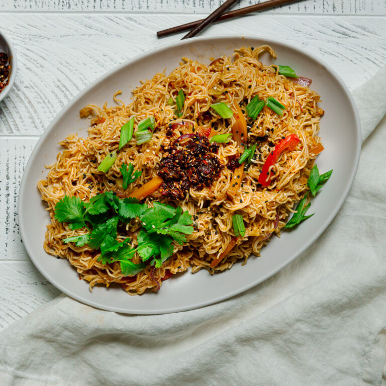 garlic chili oil noodles garnished with cilantro and chili crunch