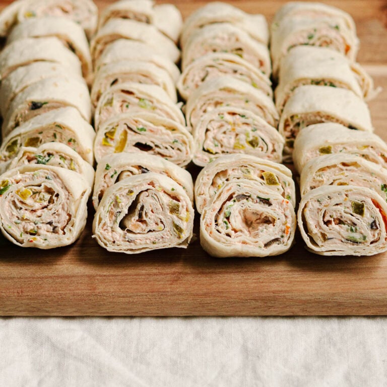 tortilla pinwheels stacked on a serving board