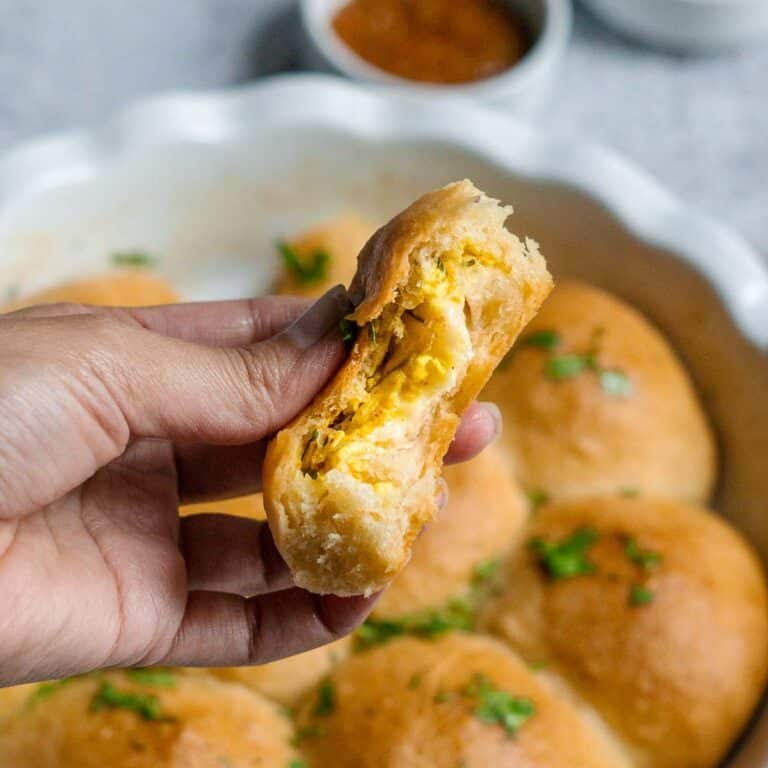 hand holding roll with cheese and paneer filling