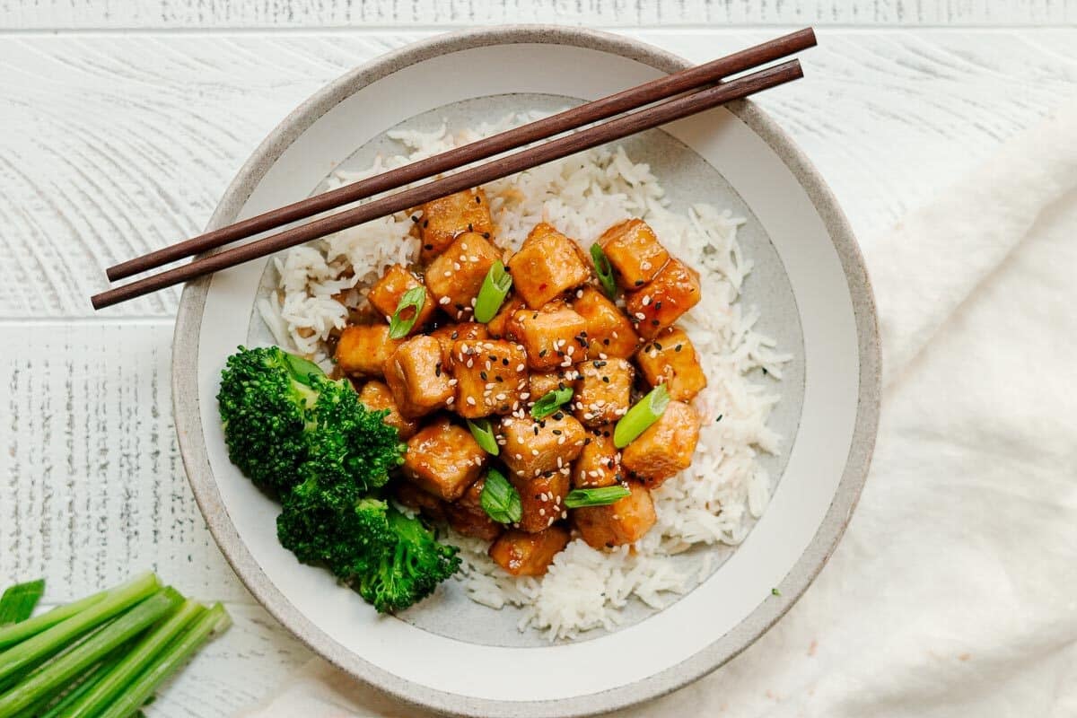 general tso's tofu wtih broccoli, topped with scallions and sesame seeds