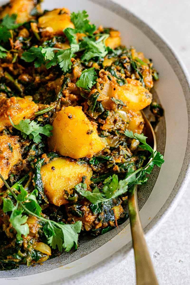 saag aloo close up garnished with cilantro