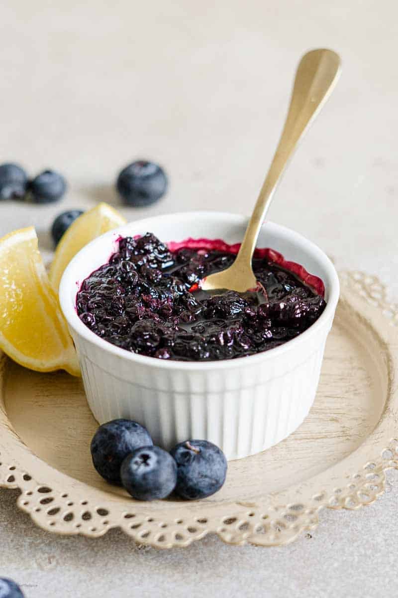 blueberry sauce with a spoon and lemon wedges